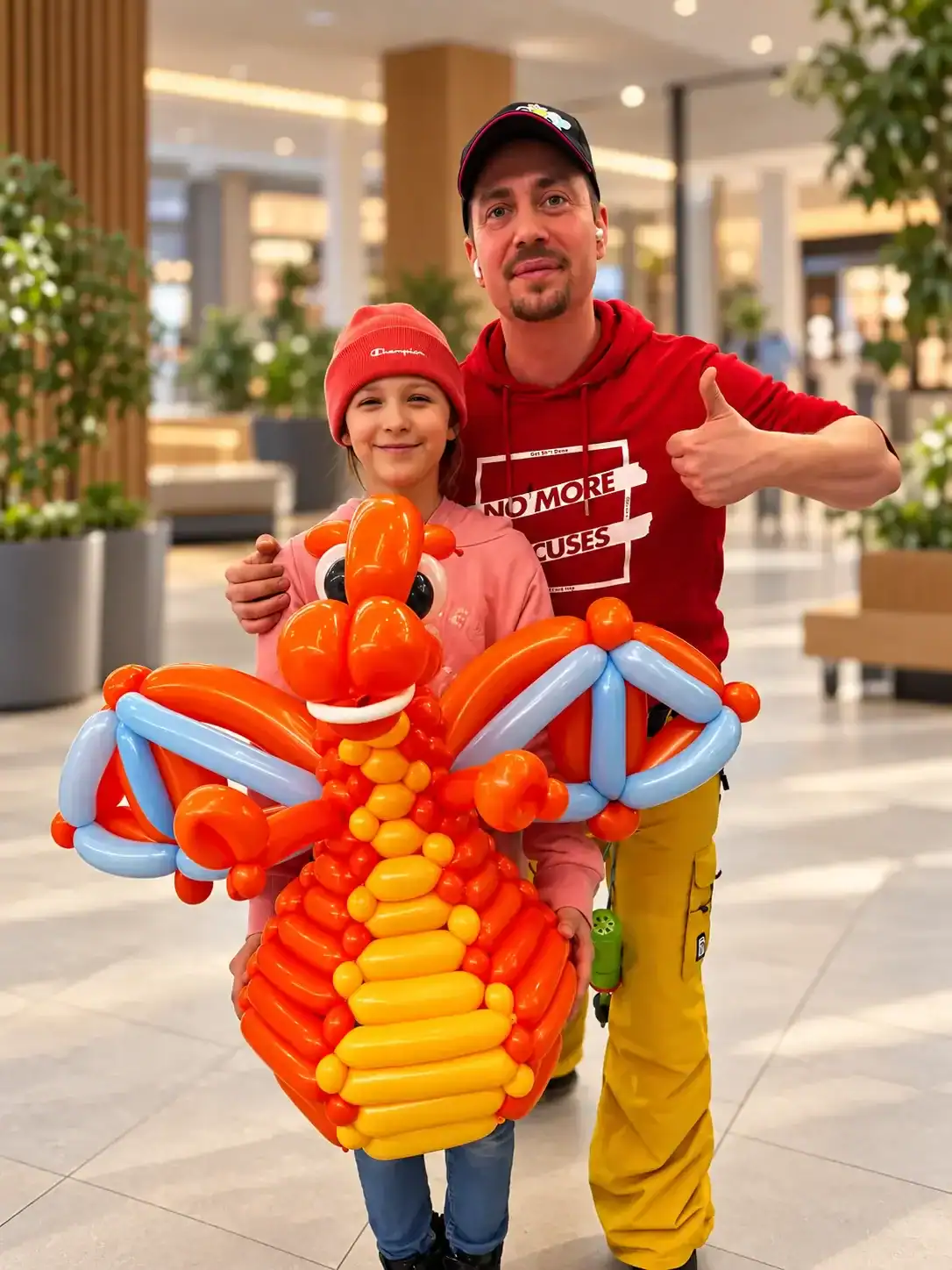 Tomáš Okurek s dítětem a velkým oranžovým balónkovým drakem